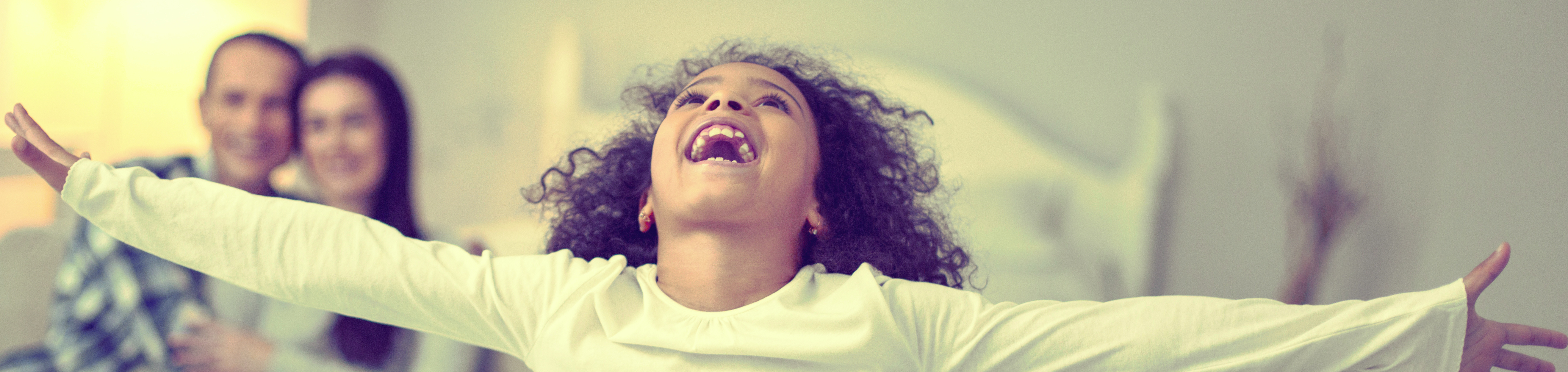 Picture of excited girl looking up with arms outstretched.